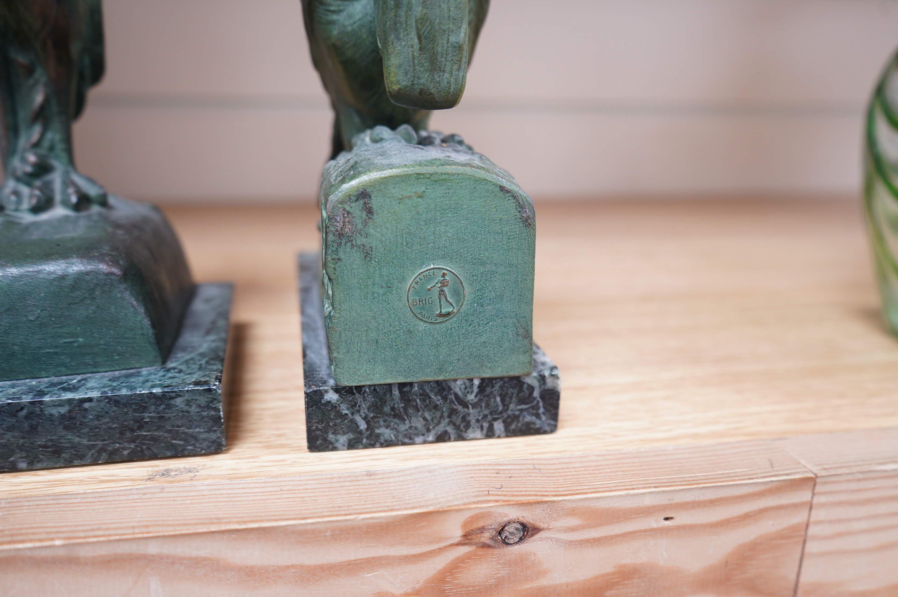 Georges Van de Voorde (Belgian 1878-1970). A pair of Art Deco bronzed spelter bookends modelled as a parrot and stork, on marble plinths, tallest 21.5cm. Condition - fair to good.